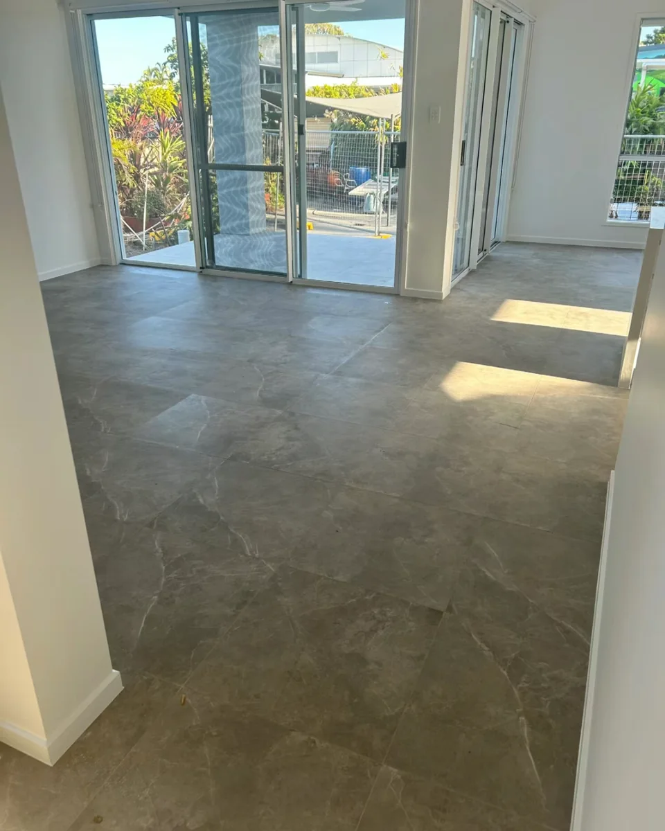 Large-format grey floor tiles installed in a bright Canberra living area.